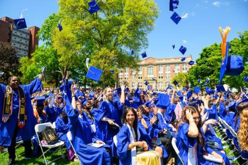 Commencement 2026 students throwing caps up into the air